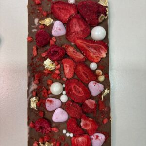 Tablette de chocolat au lait avec des fruits lyophilisées, dragées, feuilles d’or